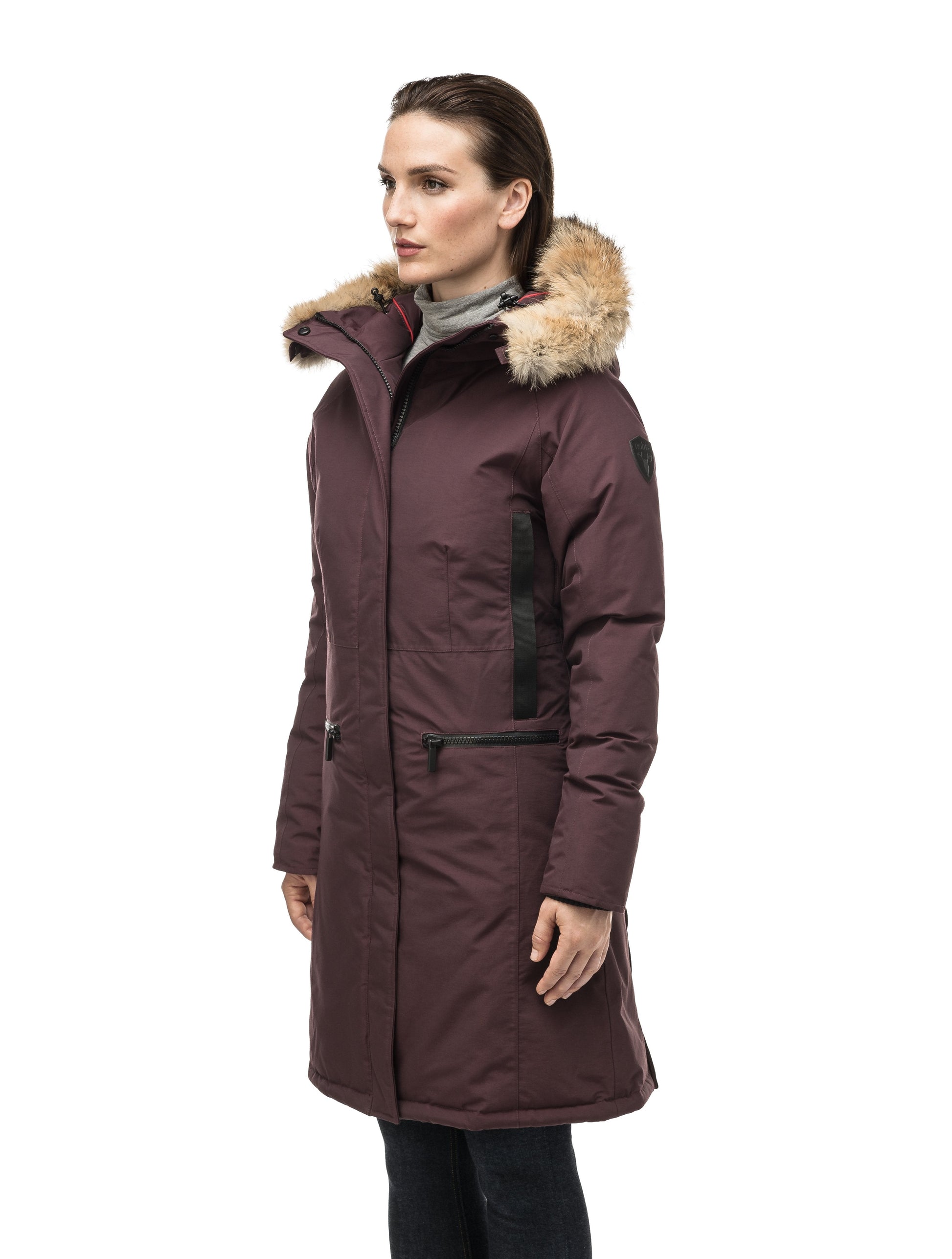 Knee length women's down filled parka with contrast ribbon accents and removable fur trim on the hood in Burgundy