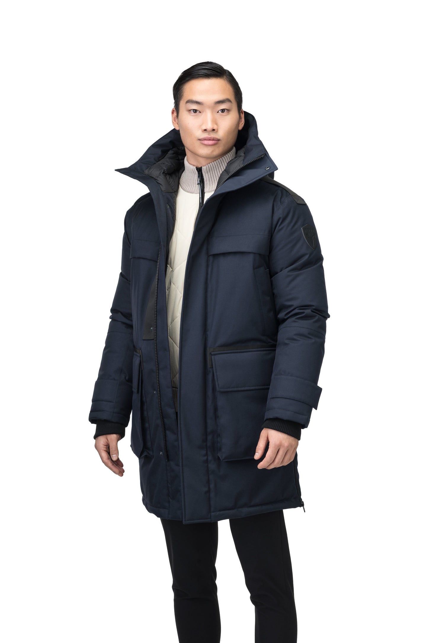 Alum Men's Long Parka in thigh length, Premium Canadian White Duck Down insulation, non-removable hood with removable coyote fur trim, two-way centre front zipper with magnetic closure wind flap, four exterior patch pockets at front, in Navy