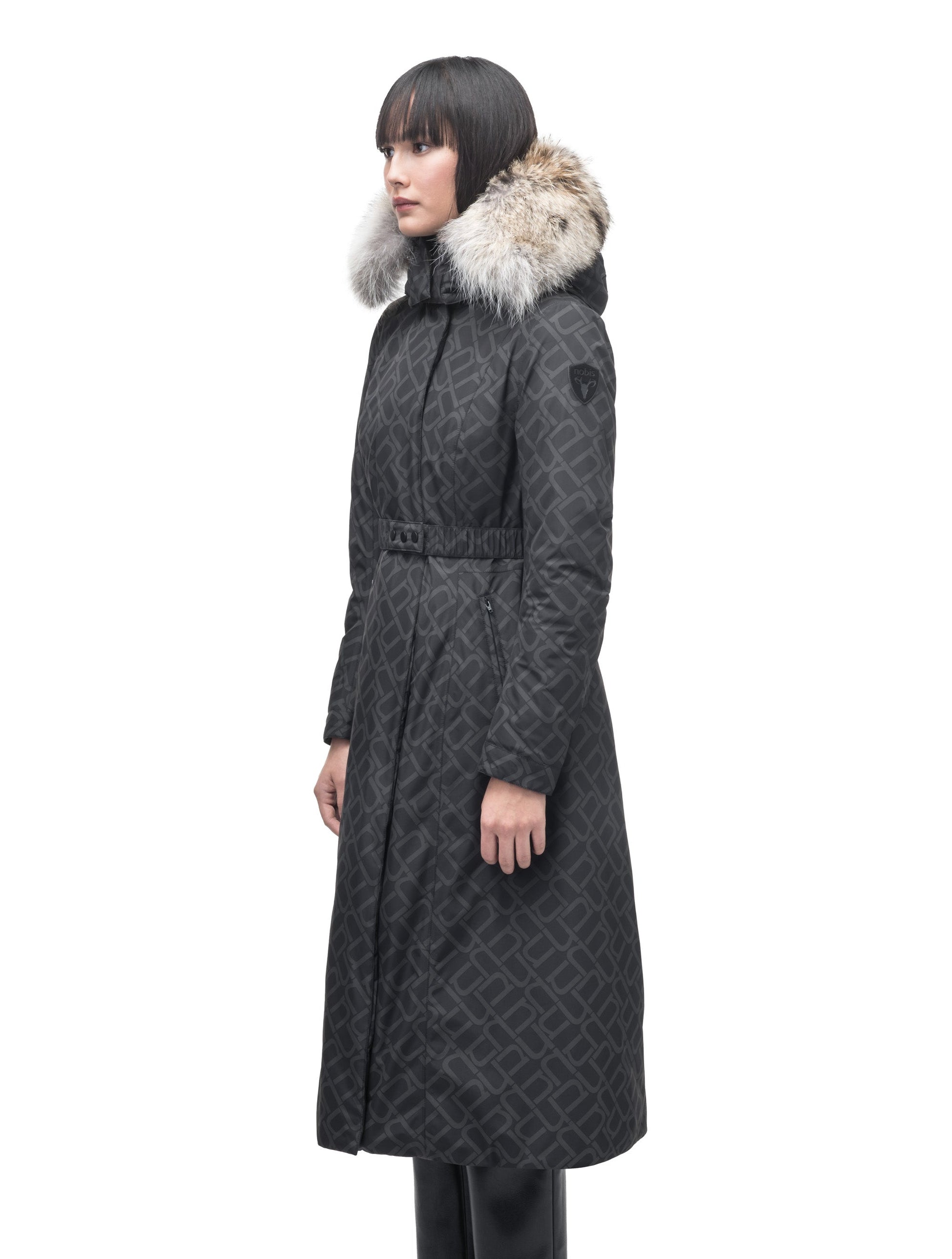 Celest Ladies Duster Parka in knee length, Canadian duck down insulation, removable hood and coyote fur trim, with adjustable belt, in Dark Monogram