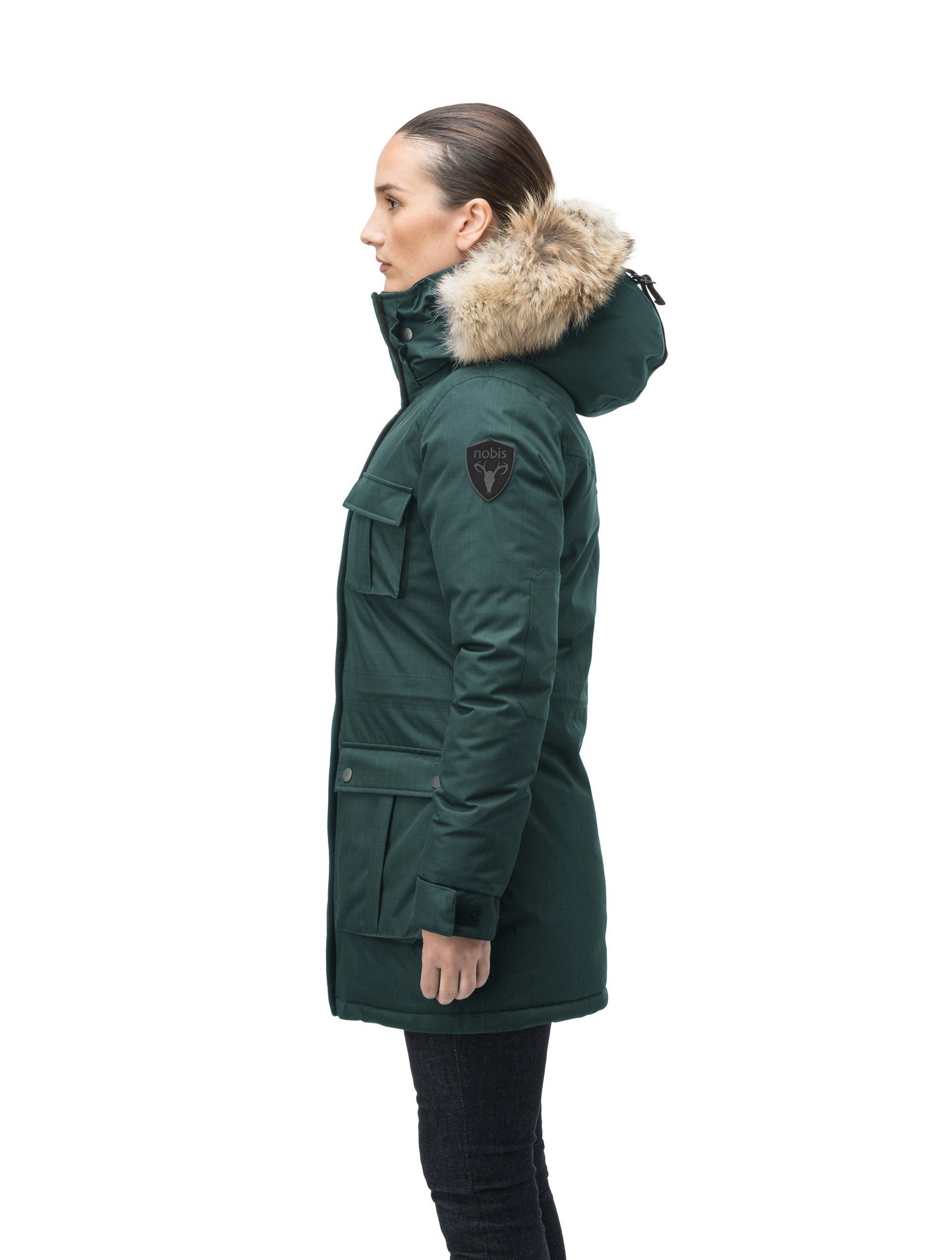 Women's down filled thigh length parka with four pleated patch pockets and an adjustable waist in CH Forest