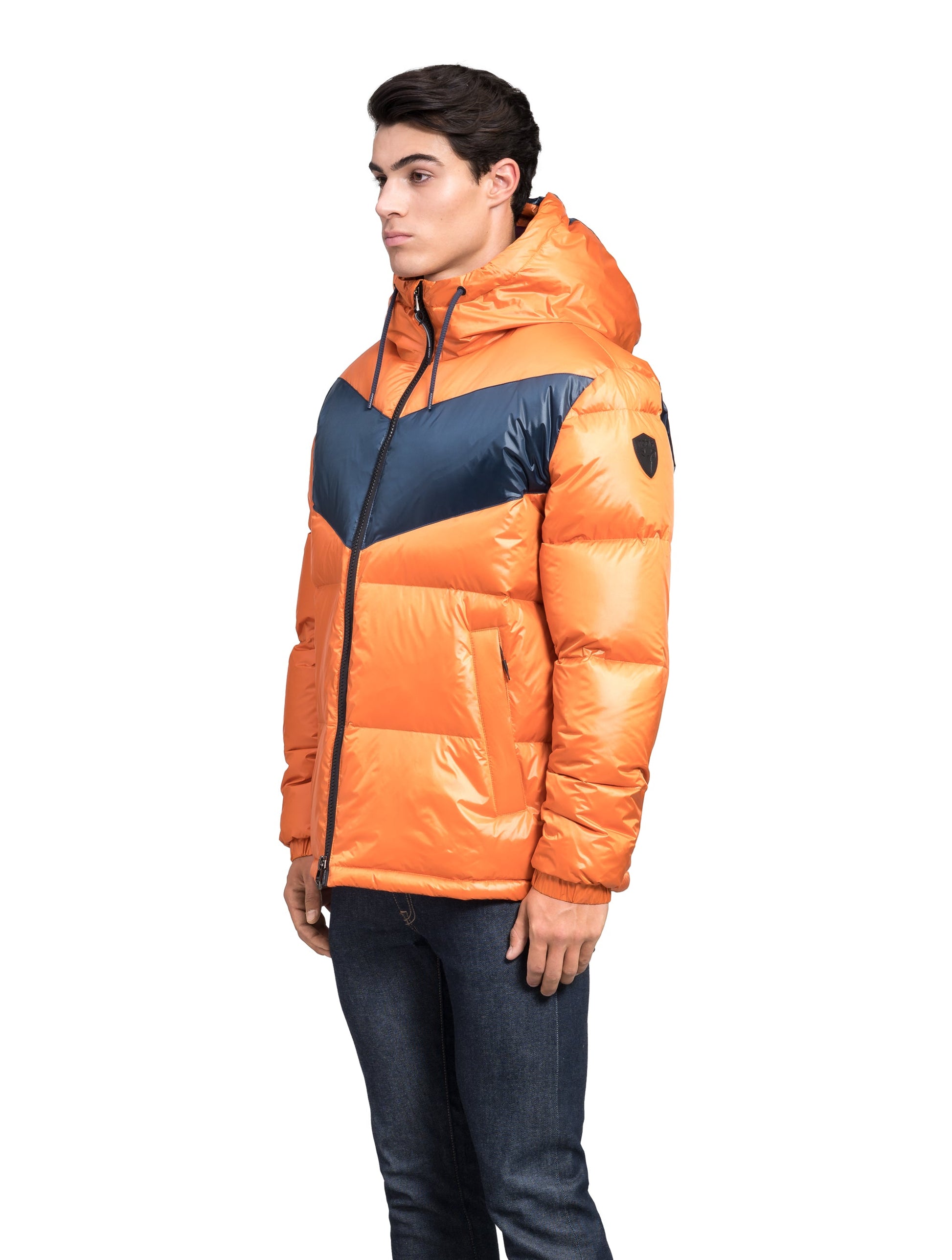 Dyna Men's Chevron Quilted Puffer Jacket in hip length, premium cire technical nylon taffeta fabrication, Premium Canadian origin White Duck Down insulation, non-removable down-filled hood, two-way centre-front zipper, fleece-lined zipper pockets at waist, pit zipper vents, in Burnt Orange