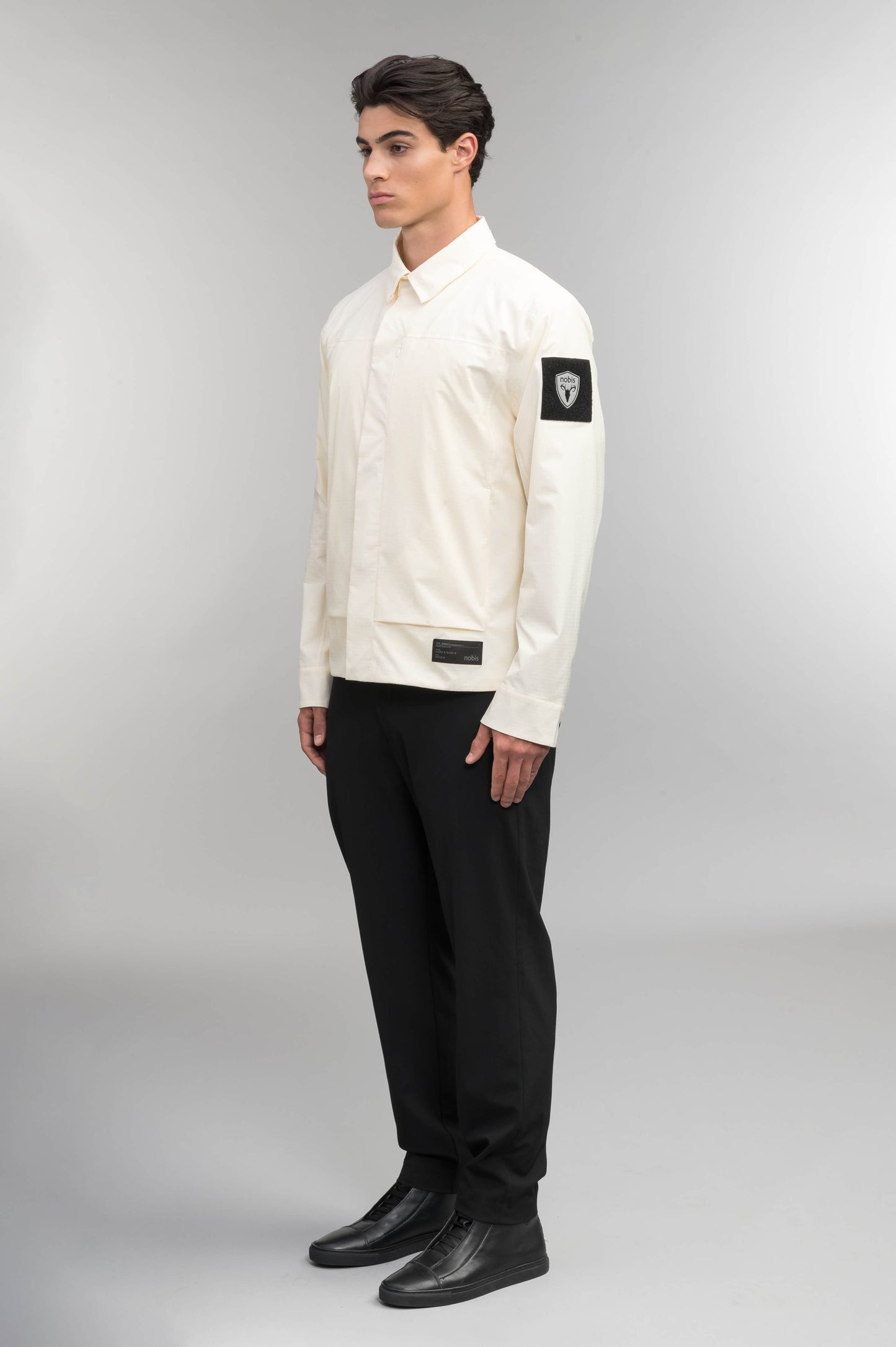 Farson Men's Waterproof Overshirt in Wheat made from premium recycled polyester ripstop with a DWR coating. Features a concealed snap-button front placket, adjustable snap cuffs, invisible chest zip pocket, dual zippered waist pockets, pit zip ventilation, and seam-sealed construction for enhanced weather protection. Designed in Canada.
