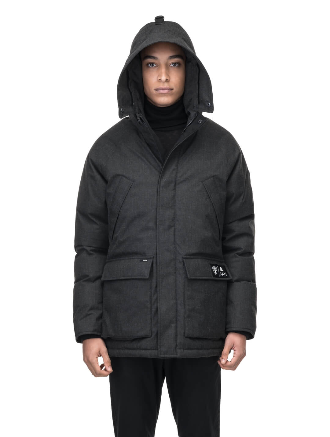 Duncan Keith Heritage Men's Parka in hip length, and features Canadian duck down insulation, non-removable hood with removable coyote fur trim, fleece-lined chest pockets, top and side entry waist pockets, adjustable waist cord, interior zipper pocket, and co-branding with Keith's signature on the left outer waist pocket, in H. Black