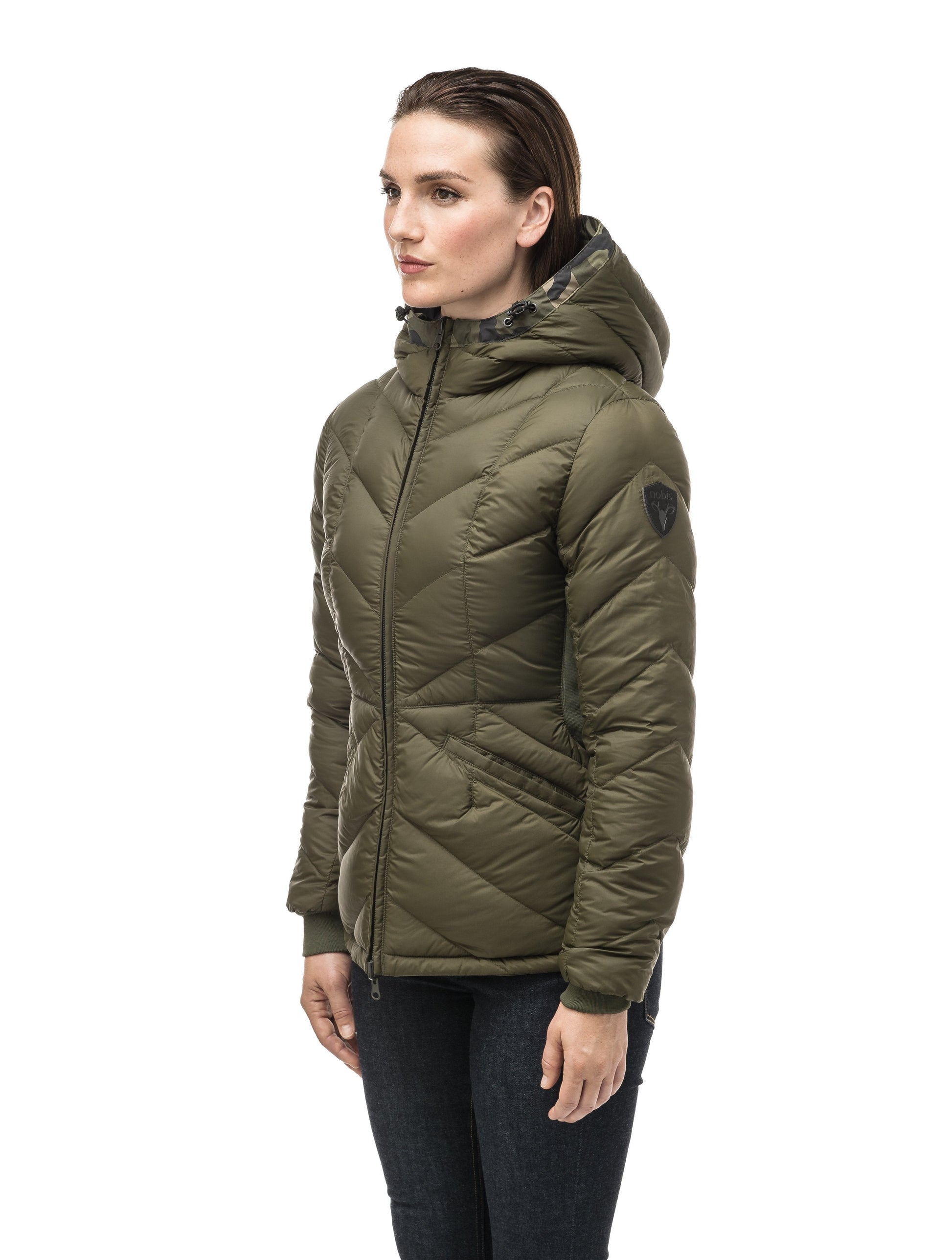 A women's two in one reversible hip length down jacket, one side is quilted and one side is solid waterproof fabric in Camo