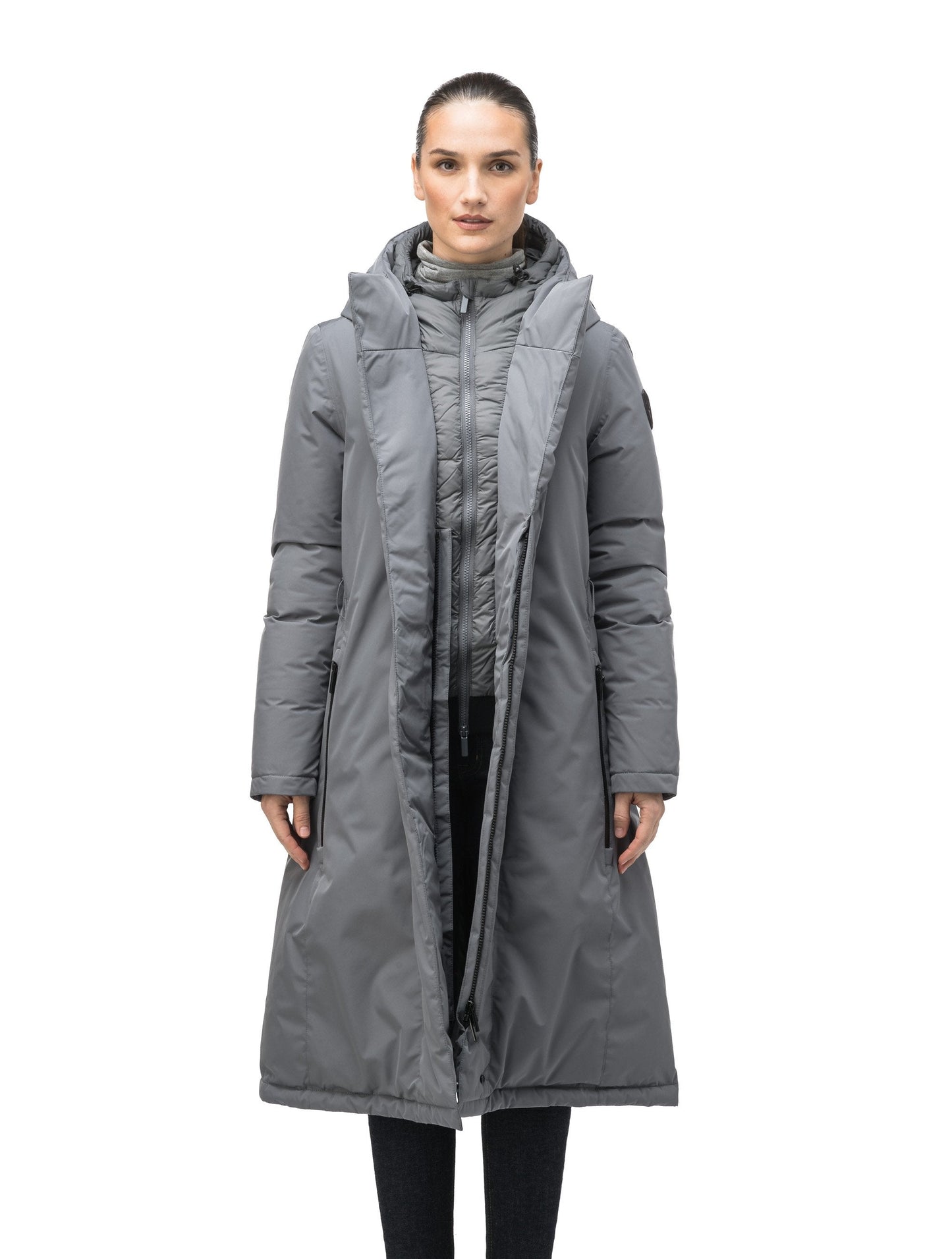 Long calf length hooded women's winter parka with an inner hip length closure, exterior hem length zipper and magentic placket in Concrete