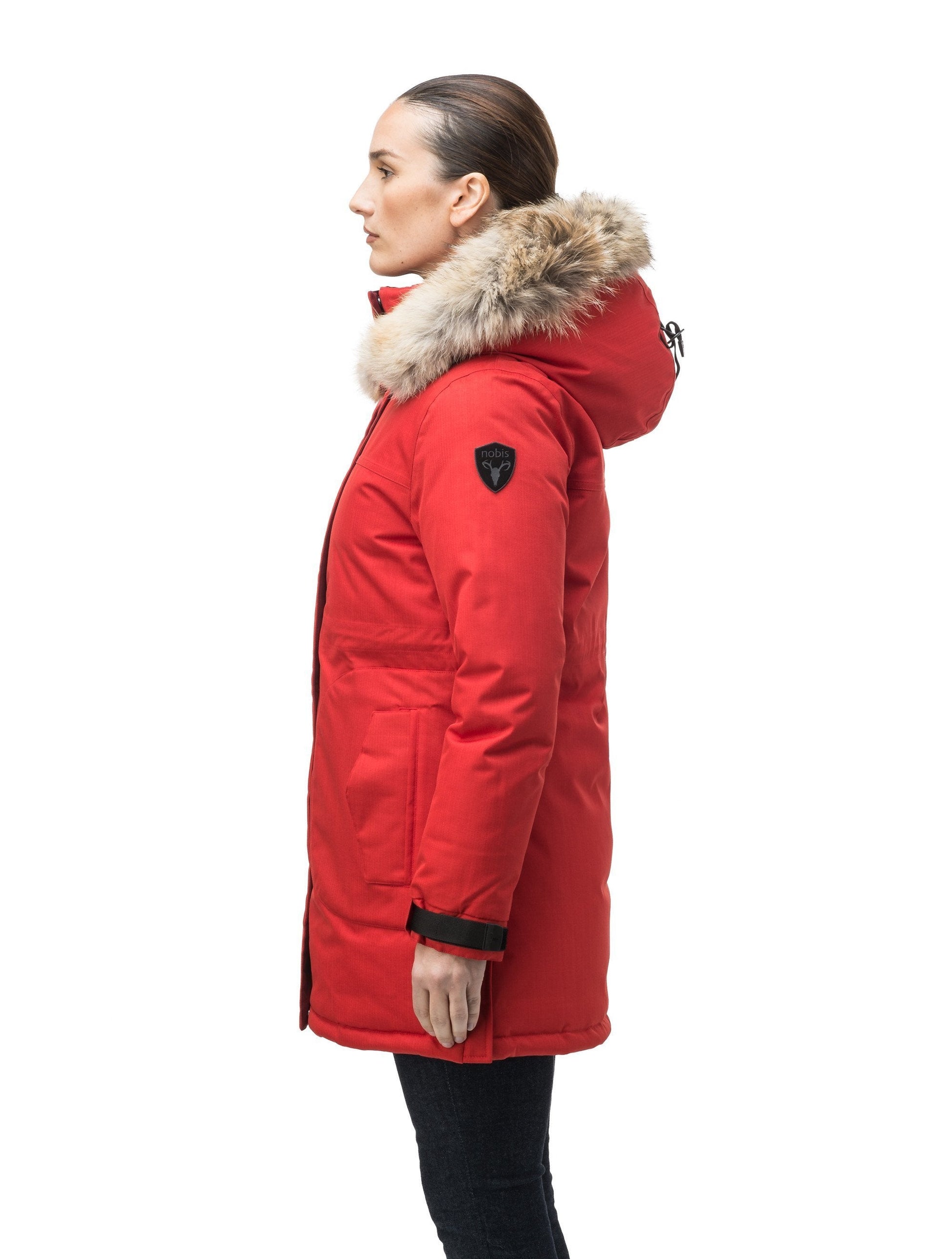 Thigh length women's down filled parka with side entry pockets and drawcord waist, removable hood and fur trim in Vermillion