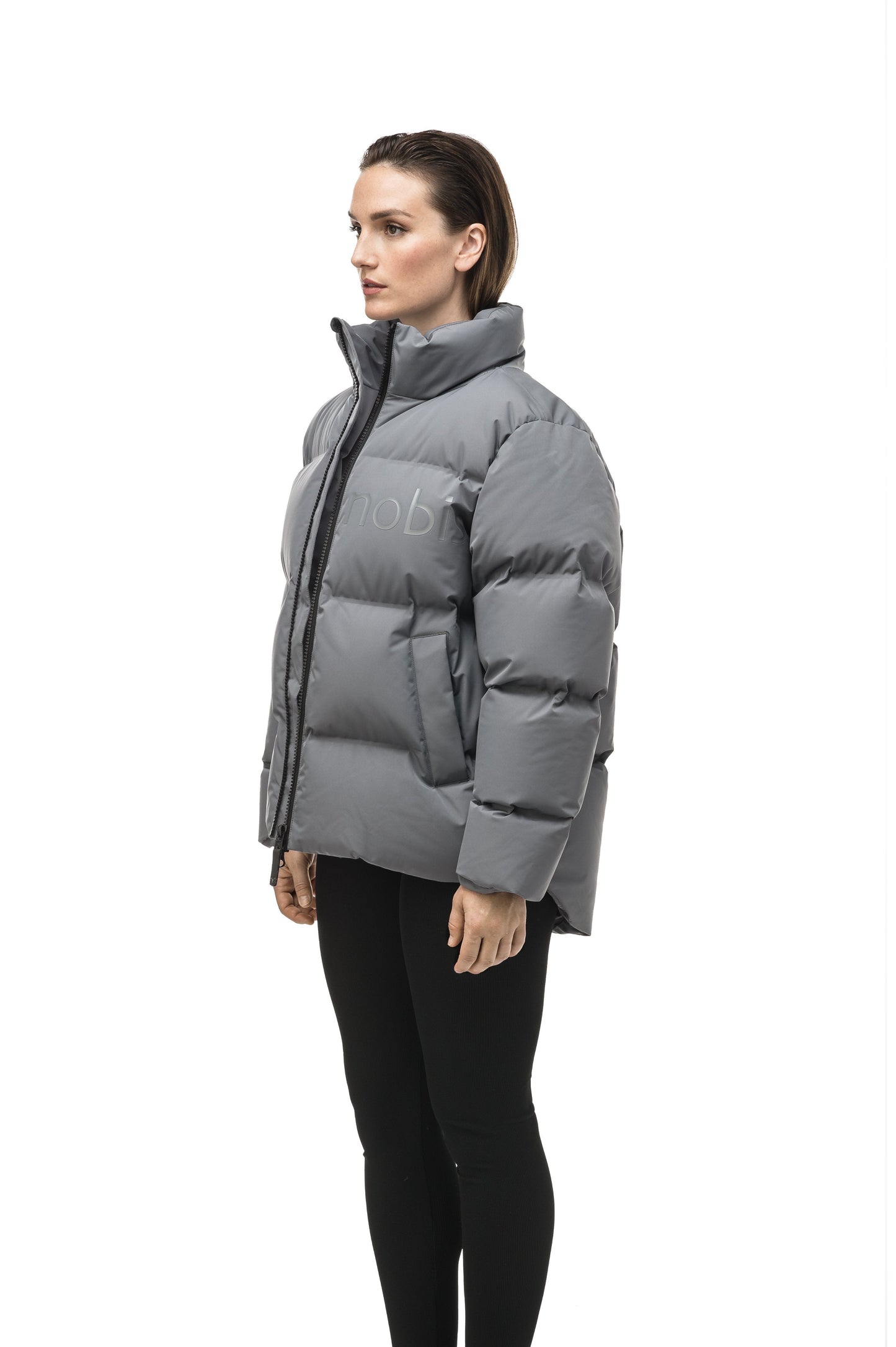 Women's puffer jacket with a minimalist modern design; featuring graphic details like oversized tonal branding, an exposed zipper, and seamless puffer channels to lock in the Premium Canadian Origin White Duck Down in Concrete color