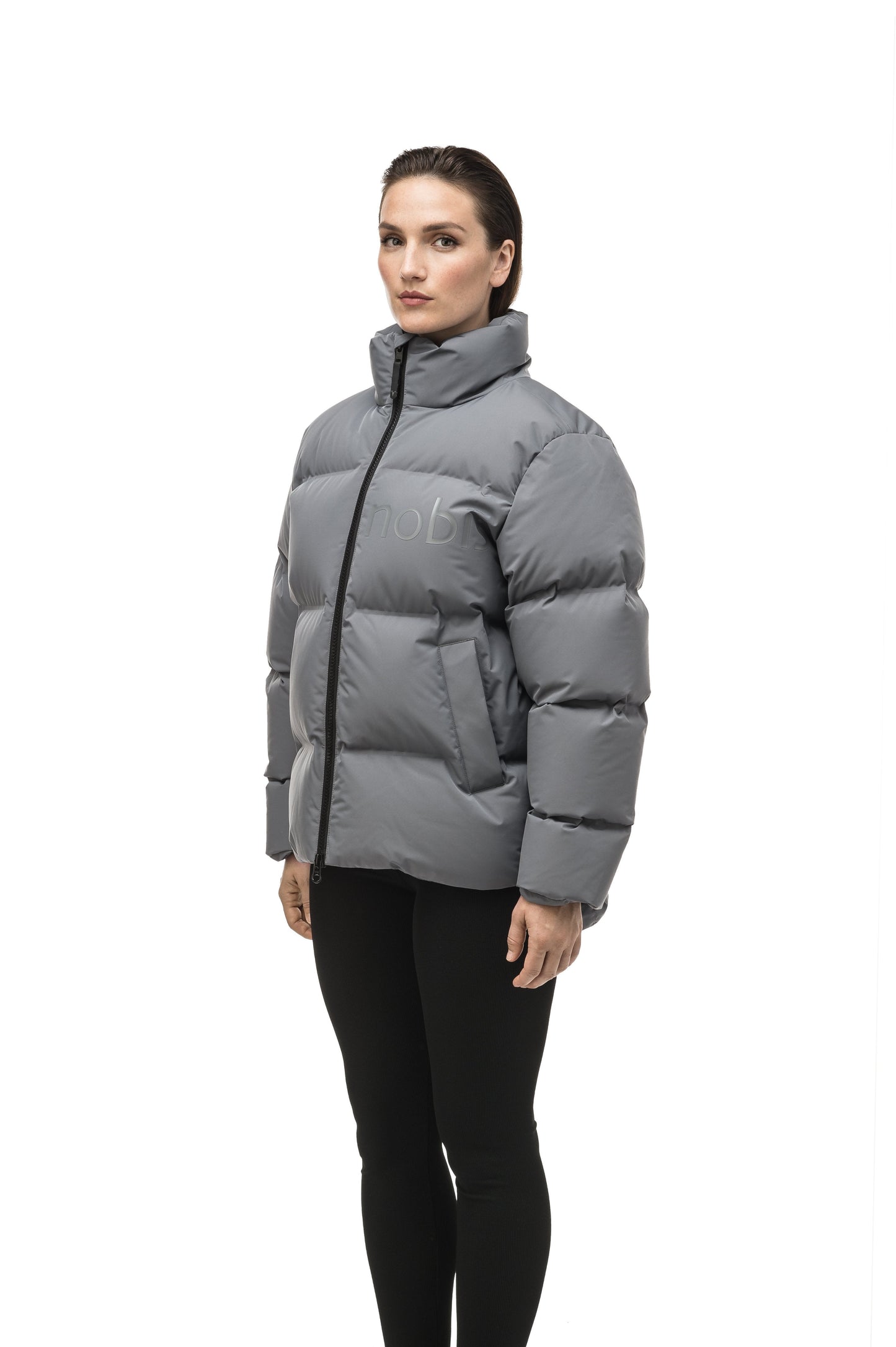 Women's puffer jacket with a minimalist modern design; featuring graphic details like oversized tonal branding, an exposed zipper, and seamless puffer channels to lock in the Premium Canadian Origin White Duck Down in Concrete color