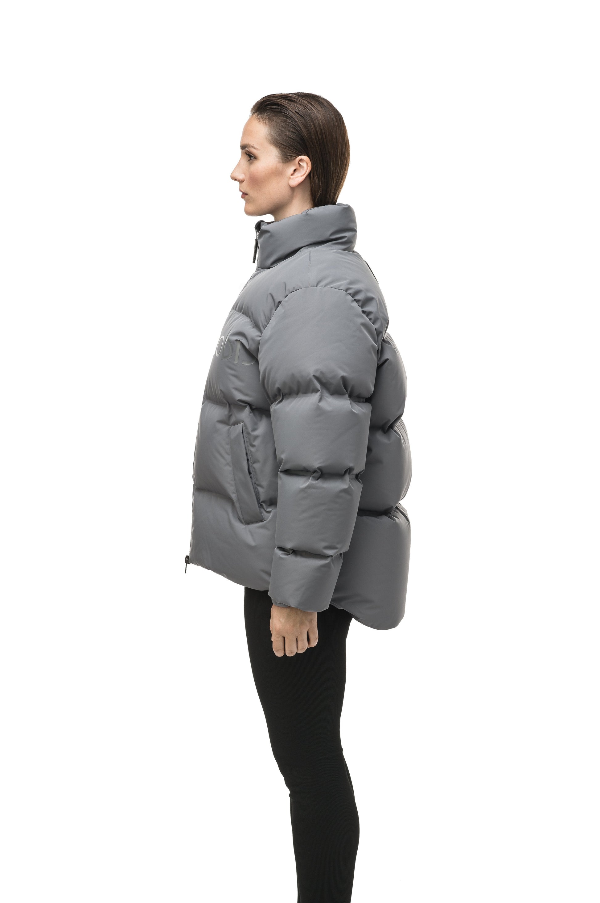 Women's puffer jacket with a minimalist modern design; featuring graphic details like oversized tonal branding, an exposed zipper, and seamless puffer channels to lock in the Premium Canadian Origin White Duck Down in Concrete color