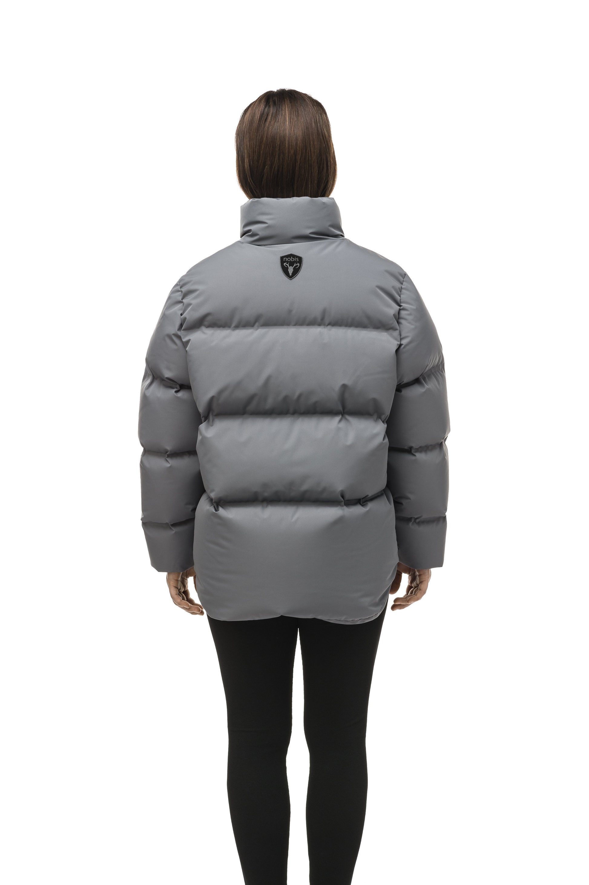 Women's puffer jacket with a minimalist modern design; featuring graphic details like oversized tonal branding, an exposed zipper, and seamless puffer channels to lock in the Premium Canadian Origin White Duck Down in Concrete color