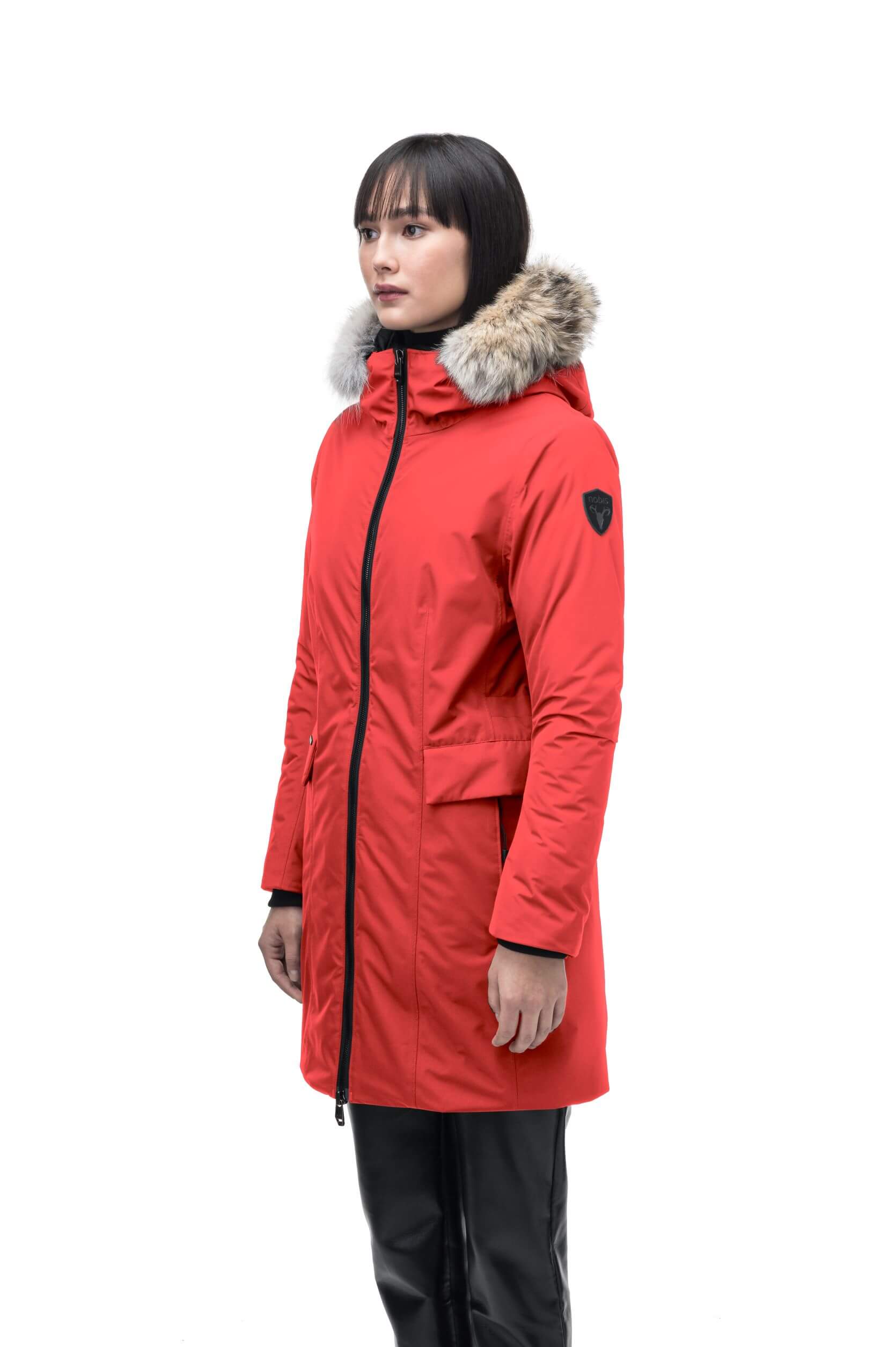 Romeda Ladies Mid Thigh Parka in thigh length, Canadian duck down insulation, non-removable hood with removable fur ruff trim, and two-way front zipper, in Vermillion