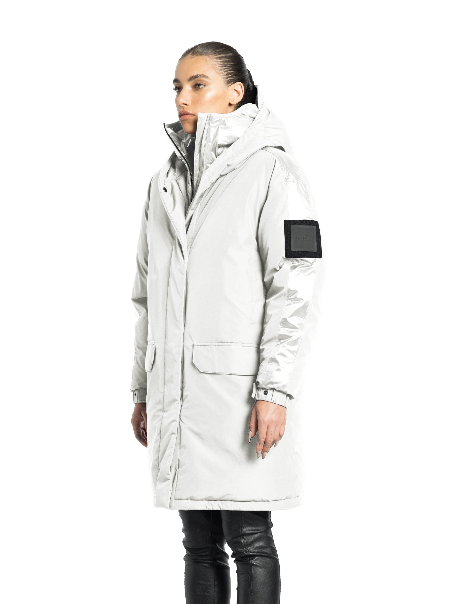 Slyn Women's Performance Parka in thigh length, premium 3-ply micro denier and cire technical nylon taffeta fabrication, Premium Canadian origin White Duck Down insulation, non-removable down-filled hood, inner hooded gilet, two-way centre-front zipper with magnetic closure wind flap, fleece-lined pockets at chest and waist, pit zipper vents, in Chalk