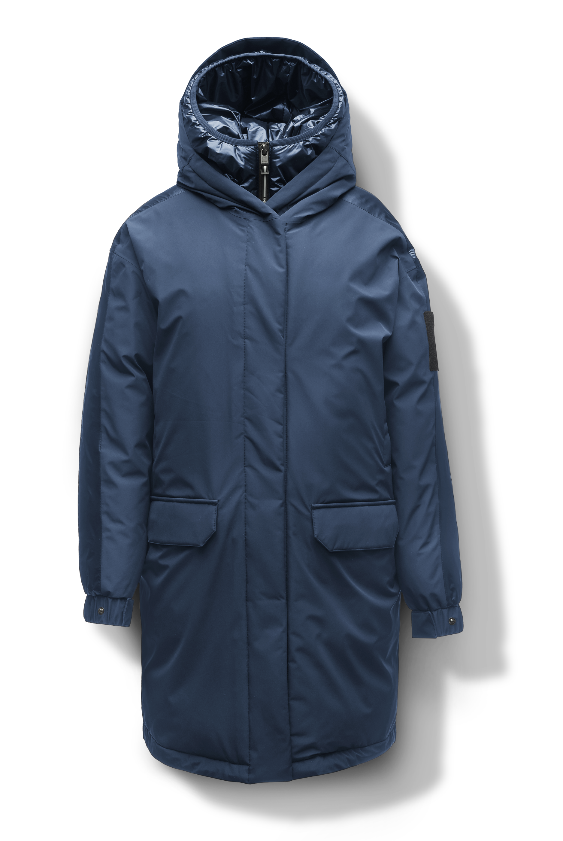 Slyn Women's Performance Parka in thigh length, premium 3-ply micro denier and cire technical nylon taffeta fabrication, Premium Canadian origin White Duck Down insulation, non-removable down-filled hood, inner hooded gilet, two-way centre-front zipper with magnetic closure wind flap, fleece-lined pockets at chest and waist, pit zipper vents, in Marine