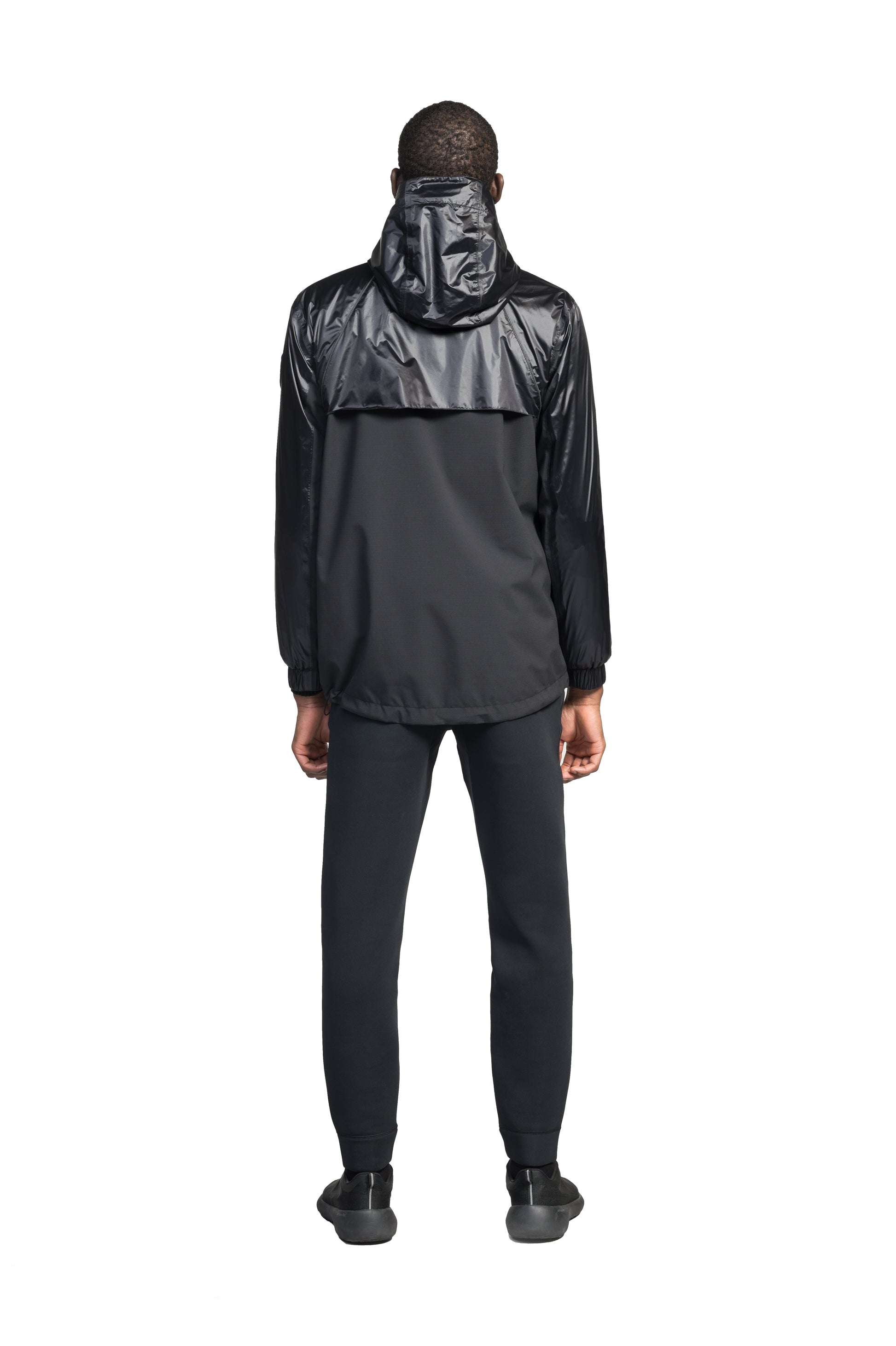 Stratus Men's Tailored Packable Rain Jacket in hip length, premium cire technical nylon taffeta and stretch ripstop fabrication, highly breathable mesh lining, hidden packable pocket, non-removable hood with adjustable draw cord, reflective piping along front and back, underarm grommets for extra breathability, back yoke with mesh ventilation, two waist zipper pockets, two interior zipper pockets, elastic cuffs with adjustable snap button, and adjustable interior draw cord at waist hem, in Black