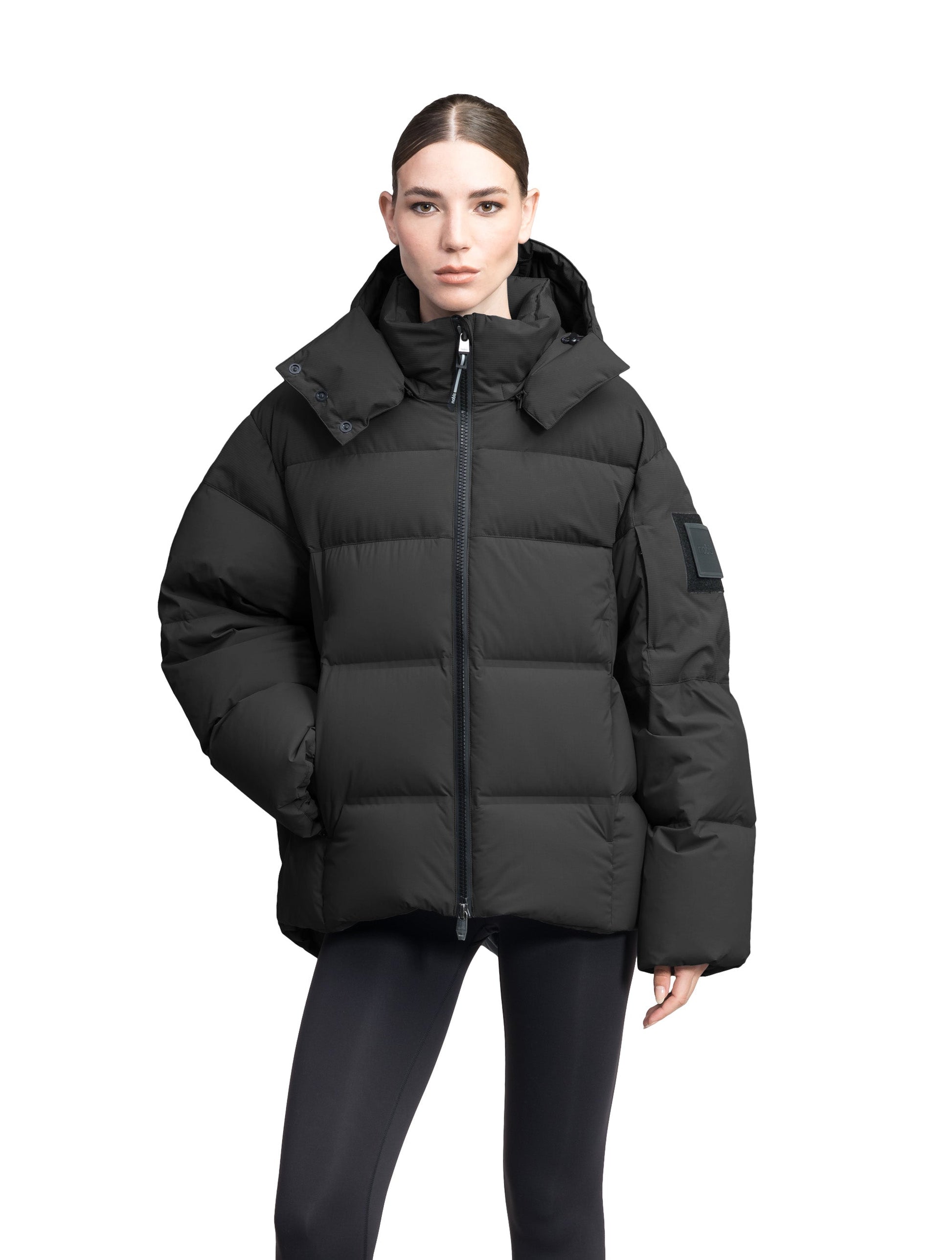 Una Ladies Performance Puffer in hip length, Technical Taffeta and Durable Stretch Ripstop fabrication, Premium Canadian White Duck Down insulation, removable down filled hood, centre front two-way zipper, and side-entry pockets at waist, in Black