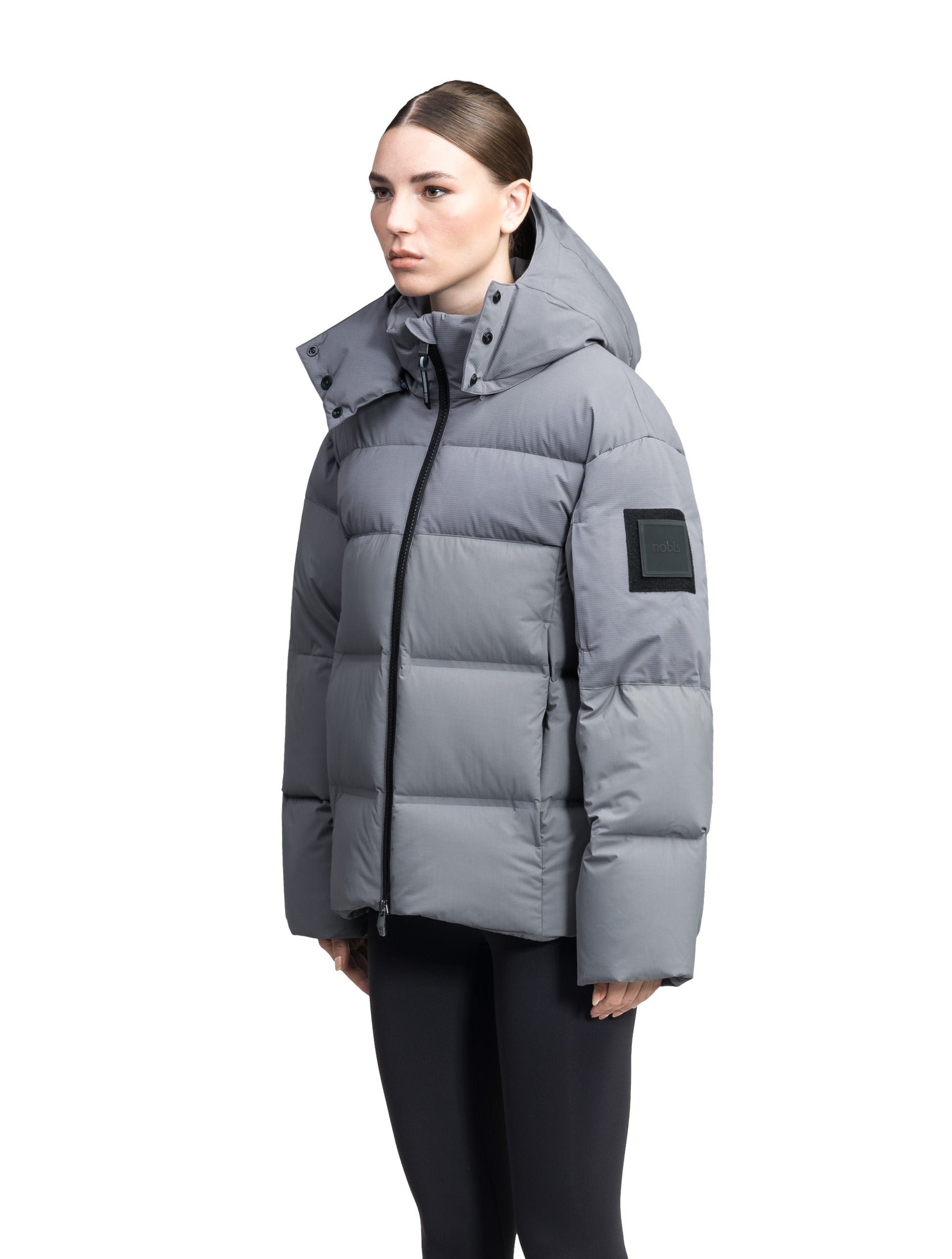 Una Ladies Performance Puffer in hip length, Technical Taffeta and Durable Stretch Ripstop fabrication, Premium Canadian White Duck Down insulation, removable down filled hood, centre front two-way zipper, and side-entry pockets at waist, in Concrete