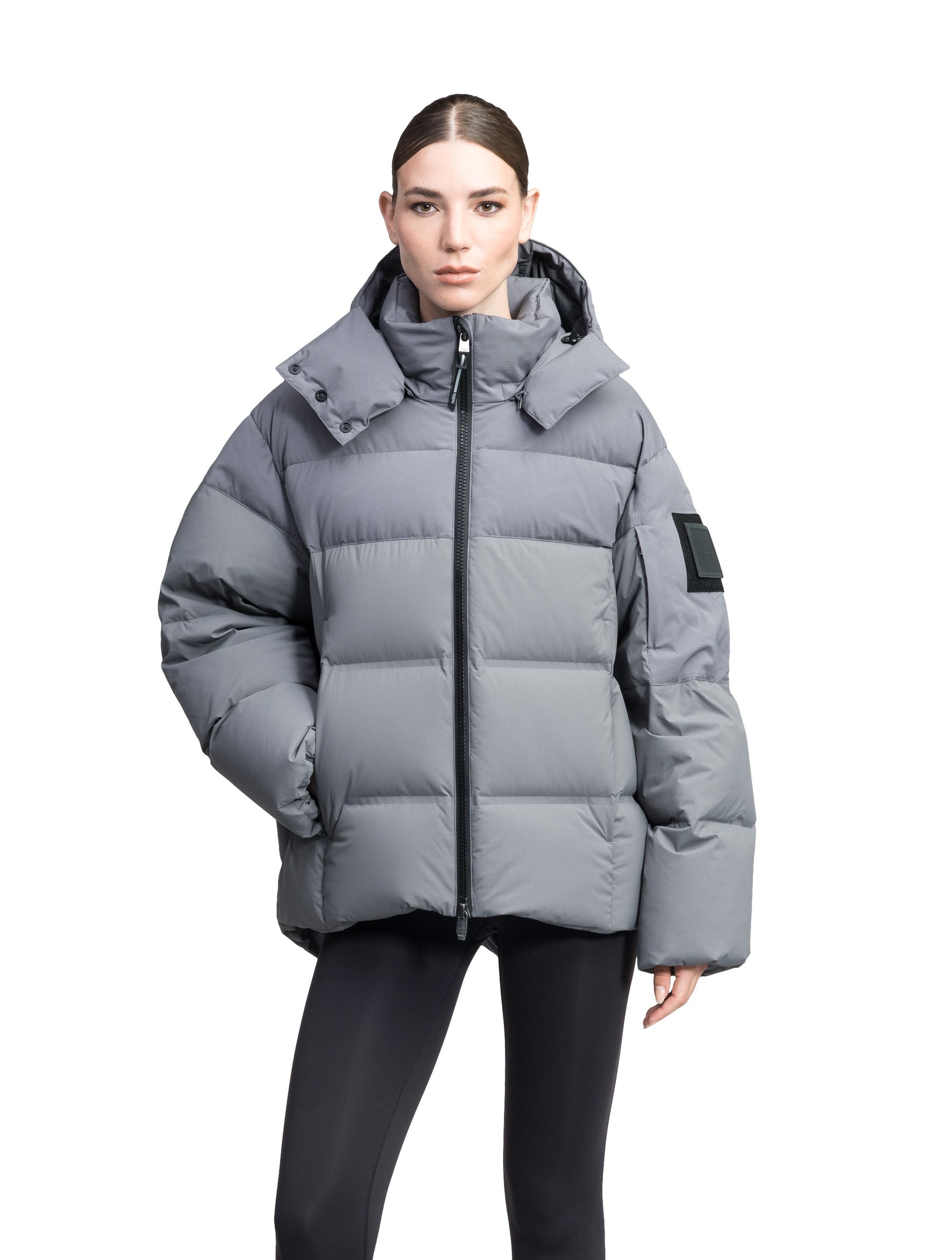 Una Ladies Performance Puffer in hip length, Technical Taffeta and Durable Stretch Ripstop fabrication, Premium Canadian White Duck Down insulation, removable down filled hood, centre front two-way zipper, and side-entry pockets at waist, in Concrete