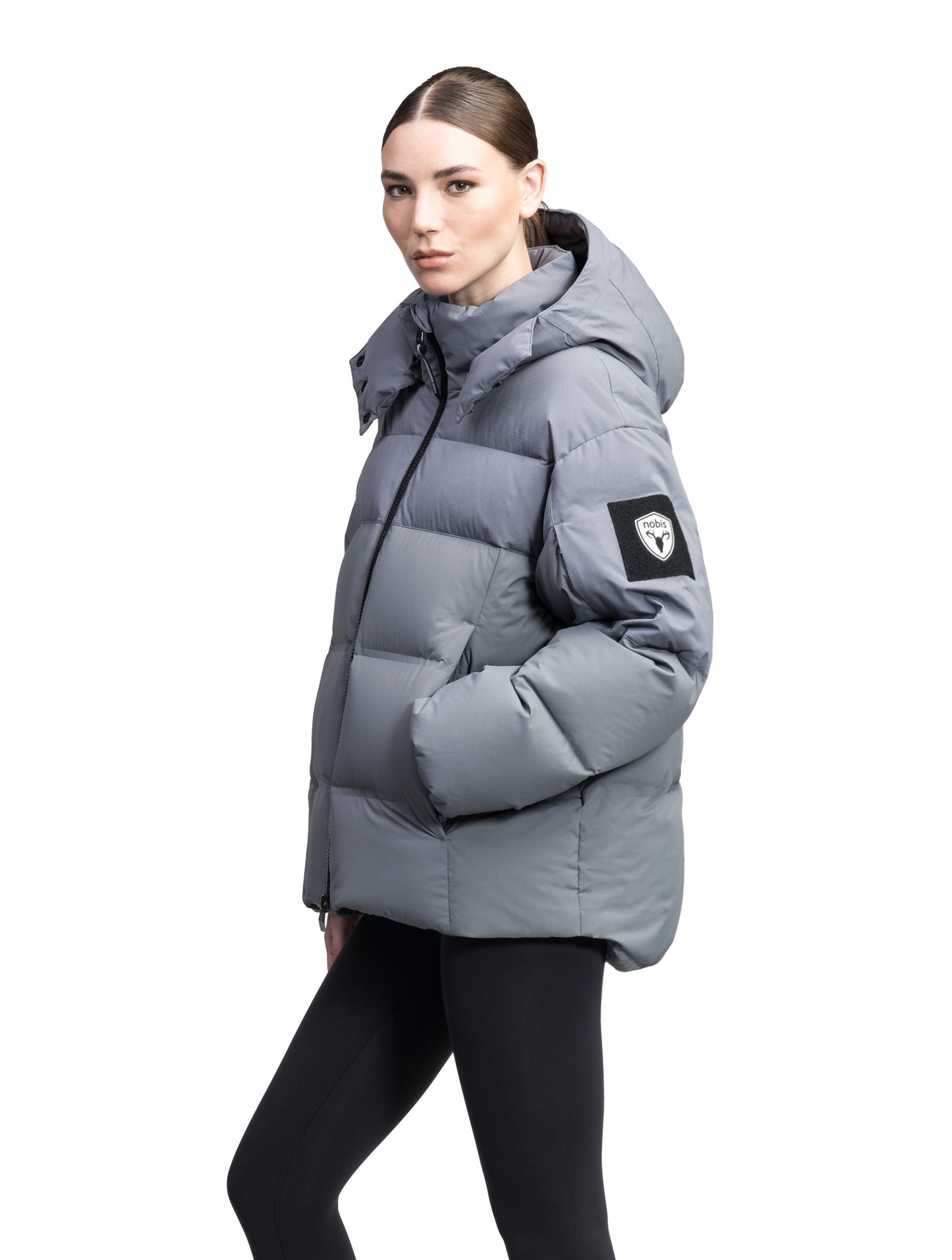 Una Ladies Performance Puffer in hip length, Technical Taffeta and Durable Stretch Ripstop fabrication, Premium Canadian White Duck Down insulation, removable down filled hood, centre front two-way zipper, and side-entry pockets at waist, in Concrete