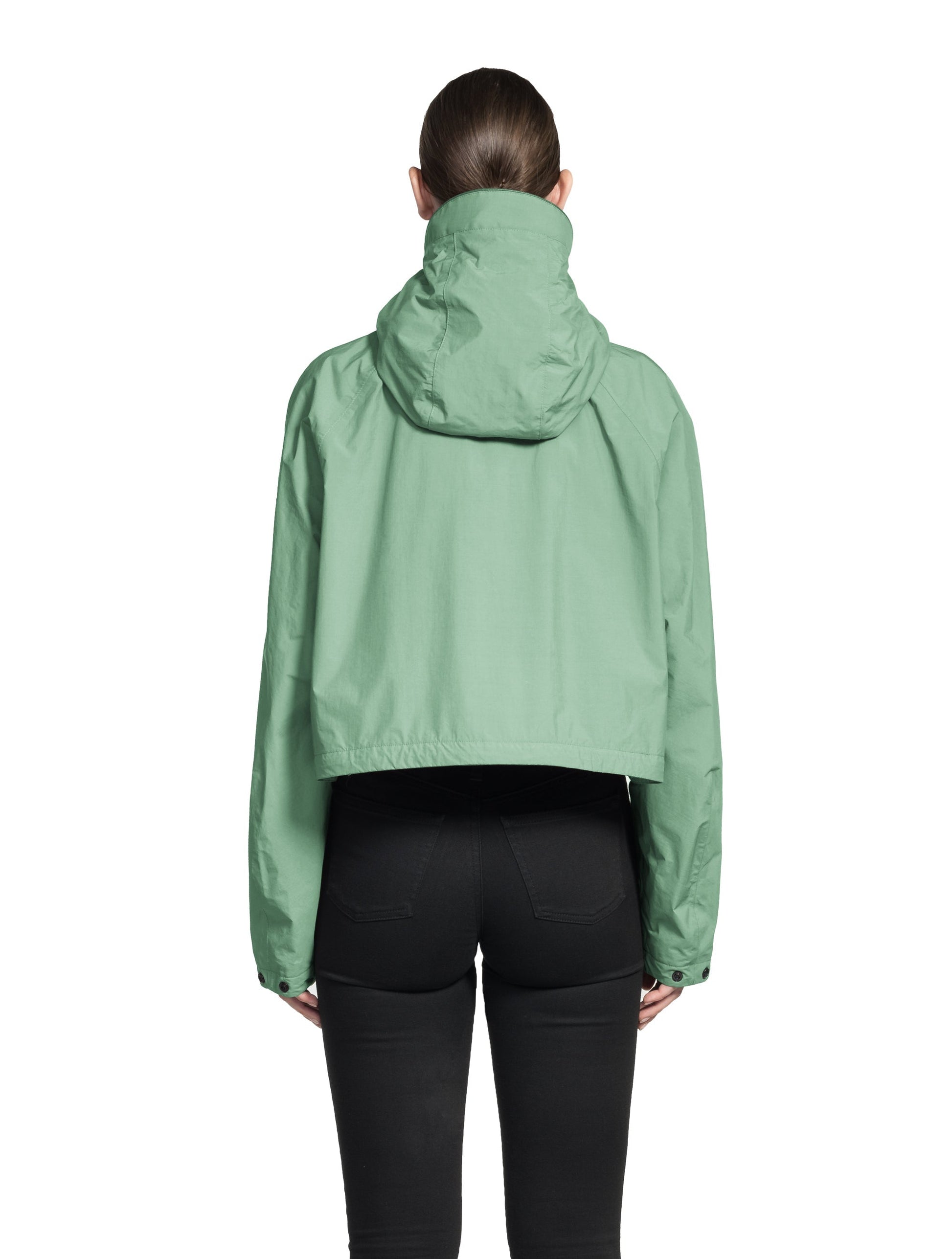 Viva Women's Performance Cropped Jacket in waist length, premium iridescent fabrication, removable hood with peak, adjustable hood draw cords and toggle, 2-way branded zipper at centre front, oversized magnetic closure flap pockets at chest with side entry, interior adjustable draw cord at hem, large interior zipper pocket, and adjustable snap cuffs, in Comfrey