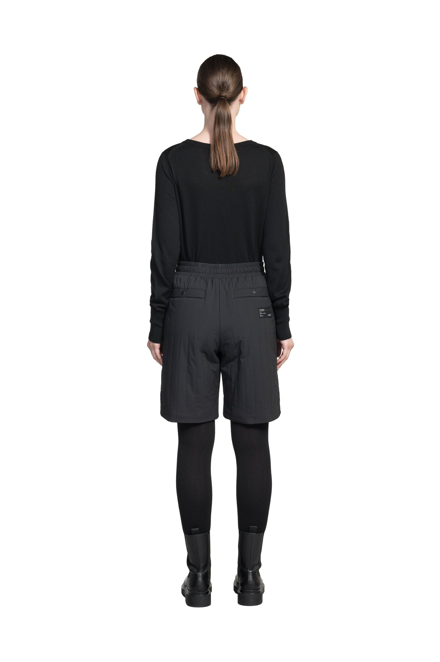 Kit Women's Quilted Shorts in knee length, premium stretch ripstop and contrast cire technical nylon taffeta fabrication, premium 4-way stretch, water resistant Primaloft Gold Insulation Active+, elasticized waistband with grosgrain ribbon drawstrings, hidden side seam toggles for rouching detail, snap closure side seam pockets at hips, and single welt snap button pockets at back, in Black