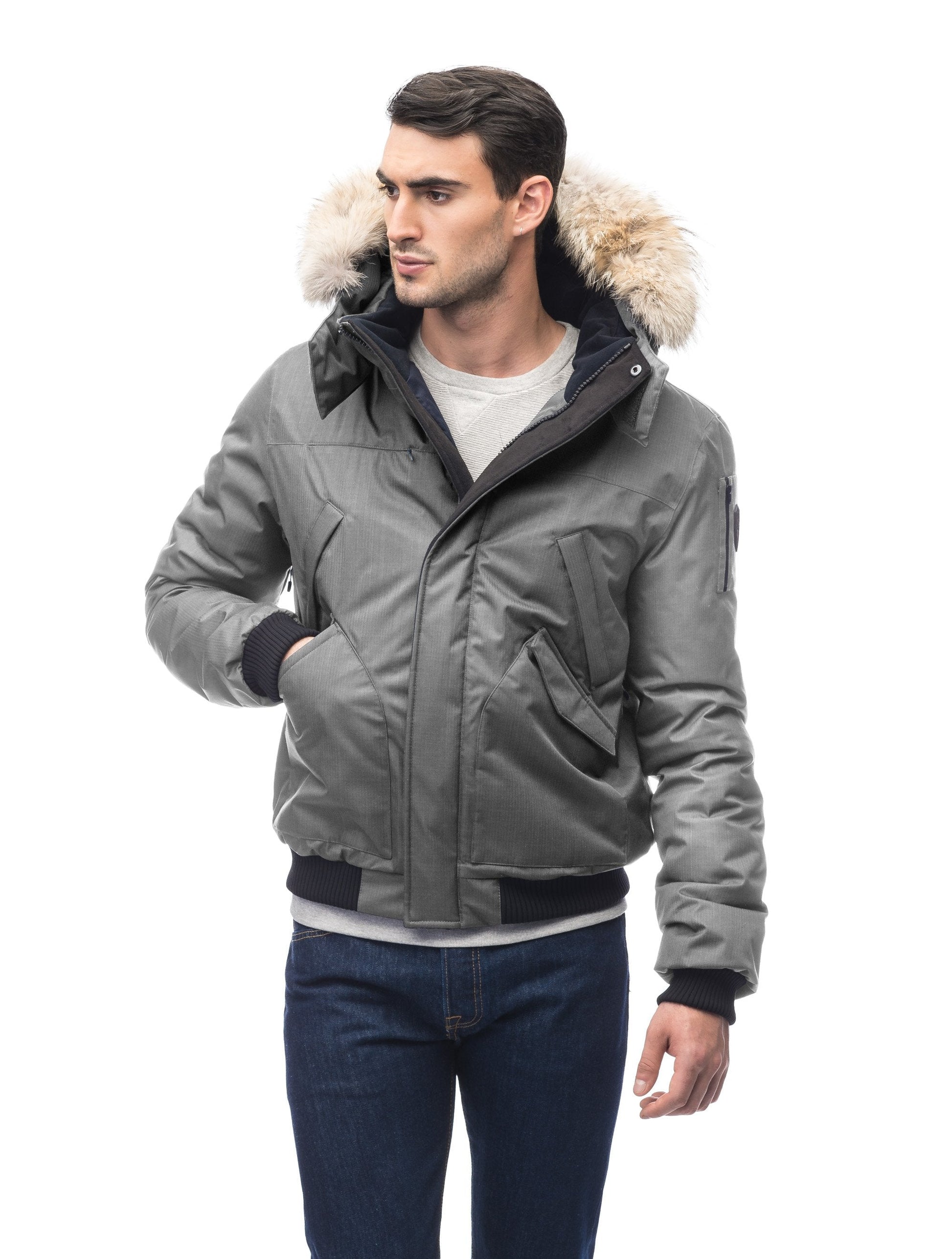 Men's classic down filled bomber jacket with a down filled hood that features a removable coyote fur trim and concealed moldable framing wire in Concrete