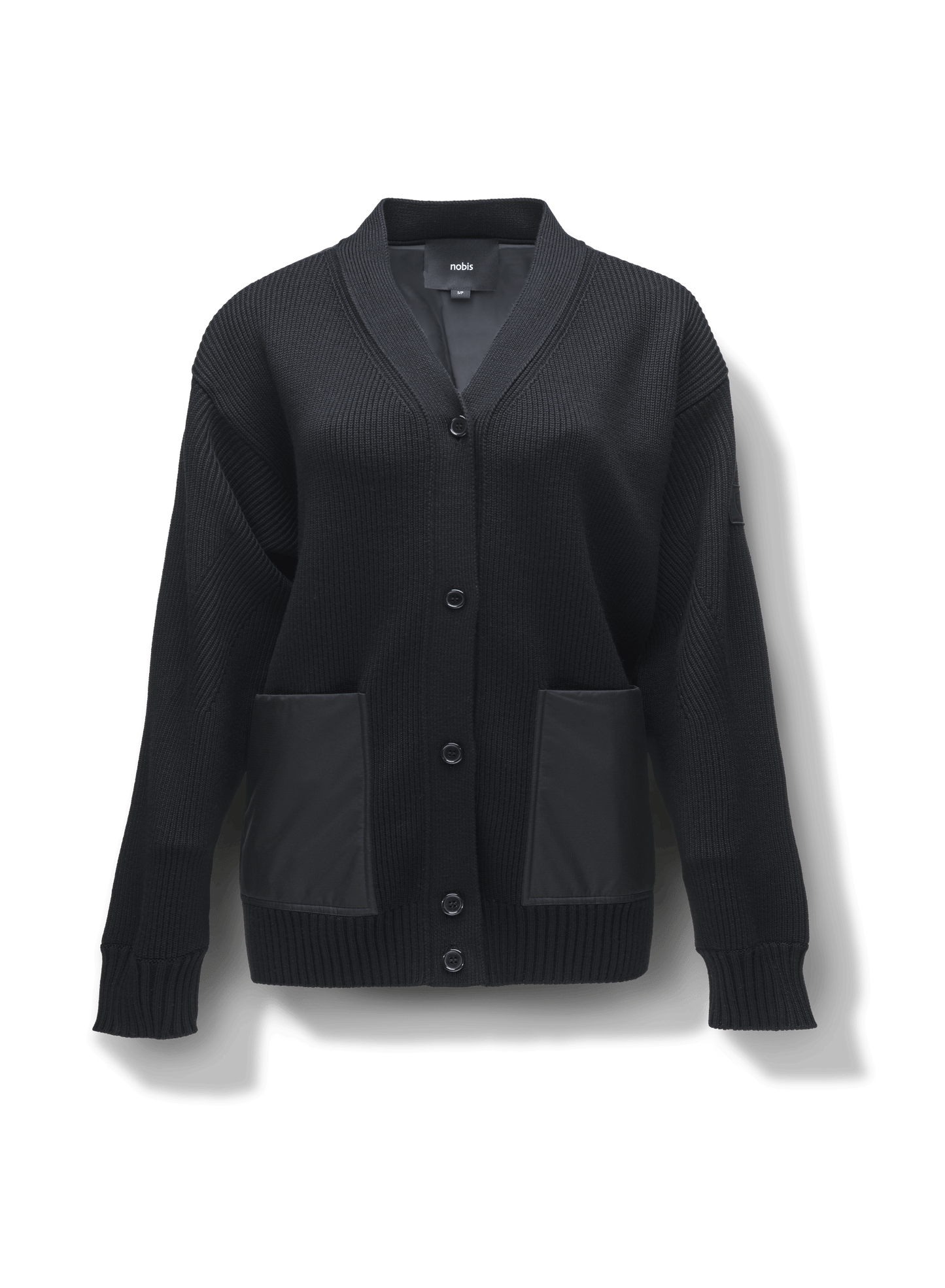 Riga Women's Tailored Button Front Cardigan in thigh length, premium virgin extra fine merino wool knit and stretch ripstop fabrication, Primaloft Gold Insulation Active+, button-front closure, quilted back detailing, front waist pockets, in Black