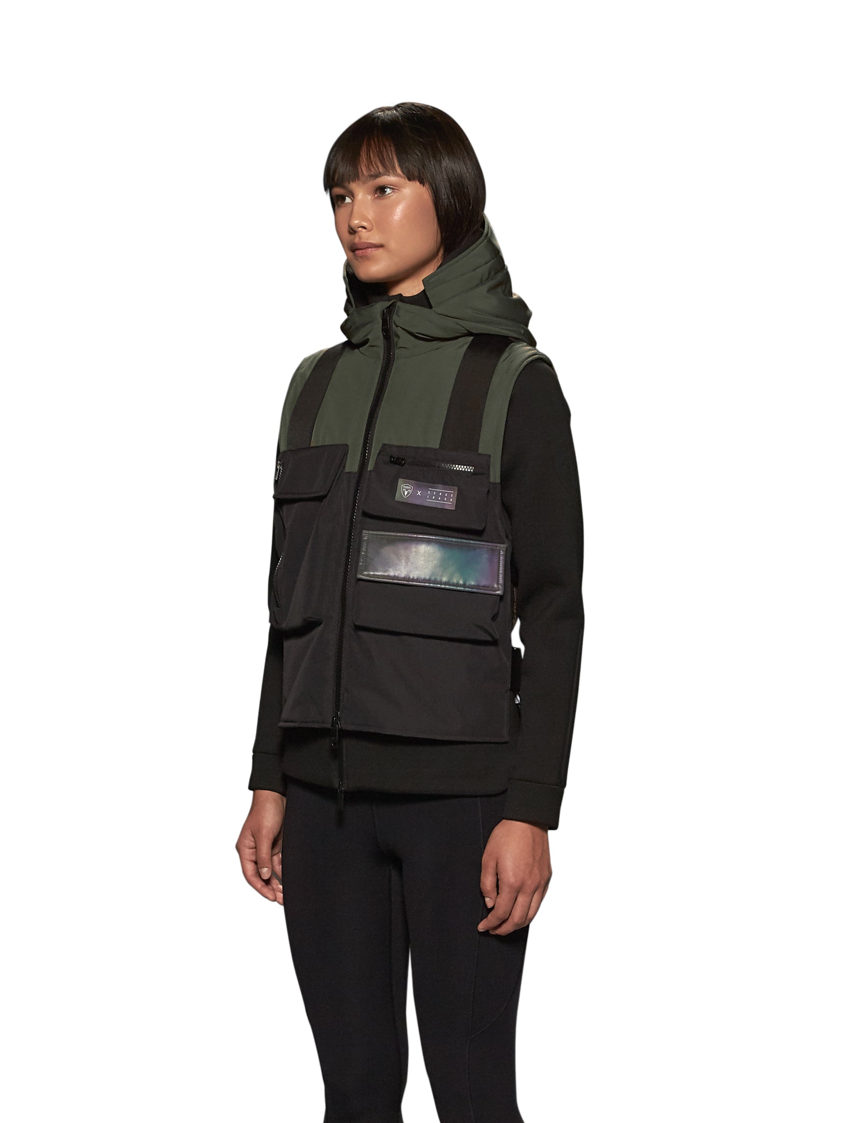 Unisex waist length hooded tactical vest with multiple exterior pockets on front and back, and adjustable side webbing fasteners, colour blocked in Fatigue/Black
